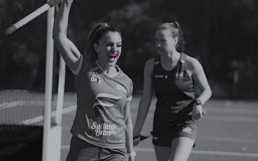 Triumphant female hockey player with Hot Purple Neomorph Mouthguard